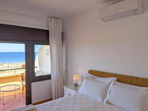 a bedroom with a bed and a view of the ocean at Seasun Vacation Rentals - OCEAN in Monte Gordo