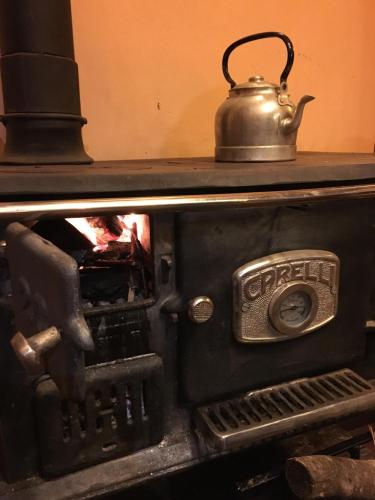 an old stove with a tea kettle on top of it at Como Entonces Posada in Uribelarrea