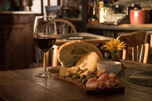 a glass of wine and a plate of cheese and bread at Como Entonces Posada in Uribelarrea