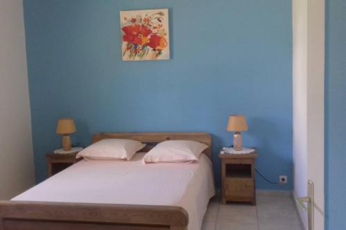ein blaues Schlafzimmer mit einem Bett mit zwei Nachttischen und zwei Lampen in der Unterkunft Aux Deux Marais gîtes magnifiques et de charme! in Saint-Louis