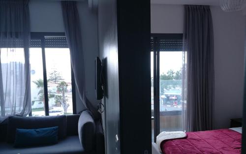 a bedroom with a bed and a large window at Crystal Palace Oualidia in Oualidia