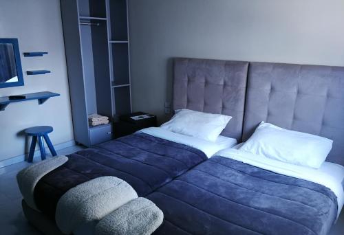 a bedroom with a large bed with a blue blanket at Crystal Palace Oualidia in Oualidia