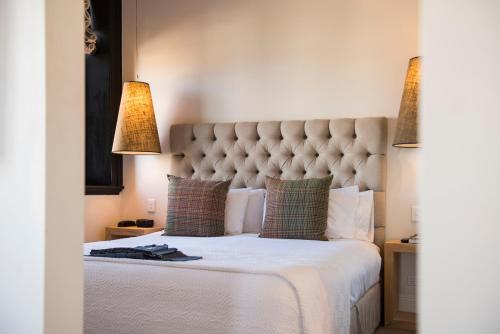 a bedroom with a large white bed with two lamps at Perry Street Hotel in Mudgee
