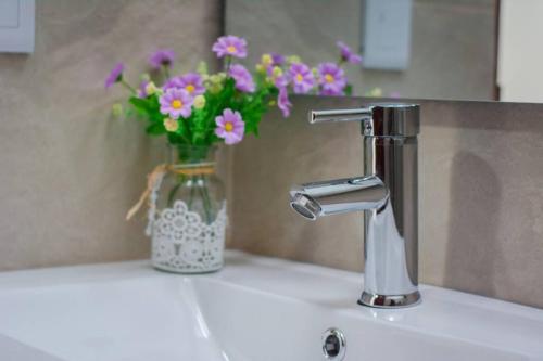 a sink with a faucet and a vase of flowers at ESPECTACULAR CASA, AMPLIA E ILUMINADA, DOTADA in Anapoima