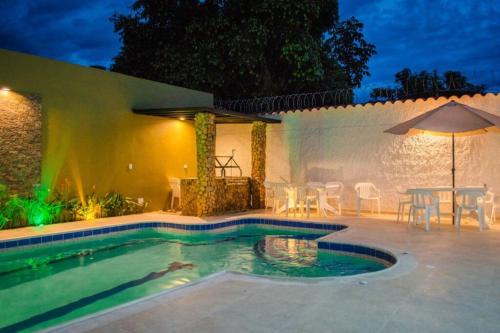 - une piscine avec une table et un parasol dans l'établissement ESPECTACULAR CASA, AMPLIA E ILUMINADA, DOTADA, à Anapoima
