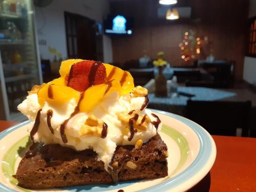 a piece of cake with whipped cream and fruit on a plate at Hostal Sisabel in Tinogasta