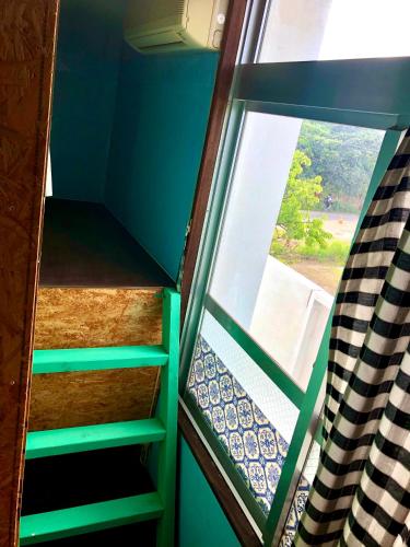 a room with a window and some stairs at Happy Island Miyako in Miyako Island