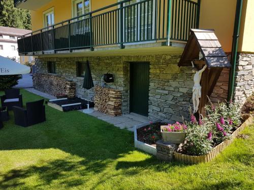 ein Haus mit Balkon und ein paar Blumen im Hof in der Unterkunft Feriendomizil Wetzelberger in Mönichwald