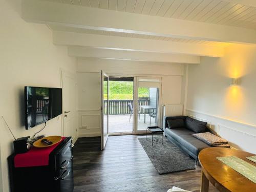 a living room with a couch and a table at Rosenhof-Lodge in Hanerau-Hademarschen