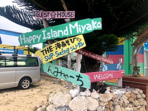 un poste con letreros de la calle frente a un edificio en Happy Island Miyako, en Isla Miyako