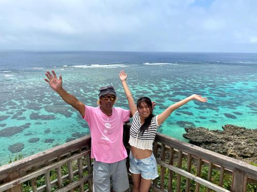 a man and a woman standing next to the ocean at Happy Island Miyako in Miyako Island