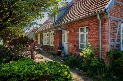 a red brick house with a garden in front of it at Ferienwohnung Familienzeit mit Sauna in Hohen Pritz