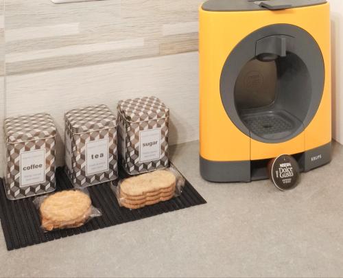 a toaster with three sandwiches next to a microwave at L'appart de la Vallée-aux-loups by Beds4Wanderlust in Châtenay-Malabry