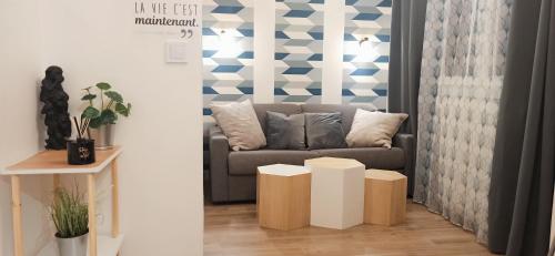 a living room with a couch and a table at L'appart de la Vallée-aux-loups by Beds4Wanderlust in Châtenay-Malabry