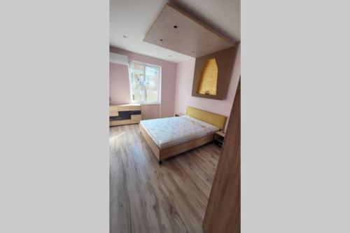 um quarto com uma cama e uma janela em Луксозен апартамент с гледка към парк и топ център em Yambol