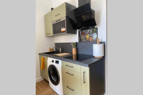 a kitchen with a washing machine and a microwave at STUDIO NEUF ET PROCHE DES PLAGES DE JUAN LES PINS in Juan-les-Pins