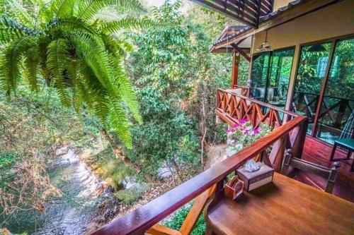 a balcony of a house with a view of a forest at Ban Mai Vintage in Pak Chong