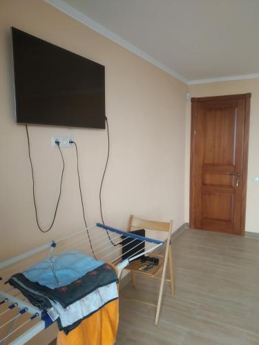 a living room with a flat screen tv hanging on a wall at Аппартаменты студия первая линия у моря в Совиньоне in Odesa