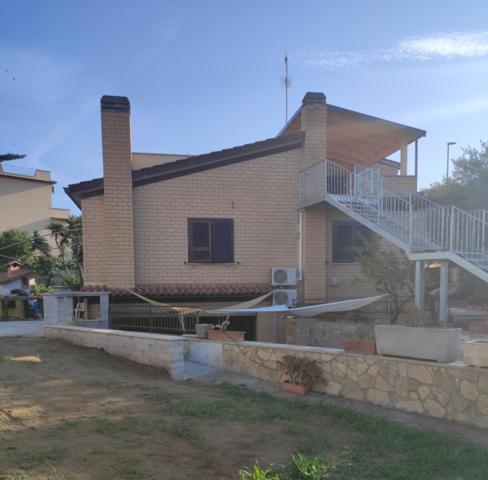 a brick house with a staircase in front of it at VILLA GIULIANA stanze con bagno interno in Villa a 350 mt spiaggia libera Lido delle Sirene in Anzio