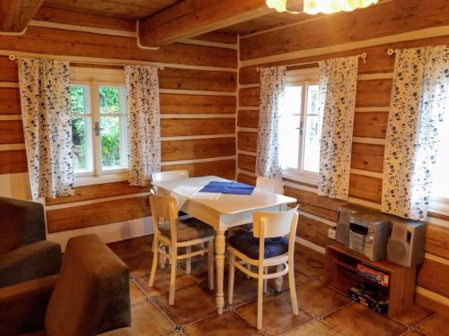 - une salle à manger dans une cabane en rondins avec une table et des chaises dans l'établissement Medová chalupa, à Hronov
