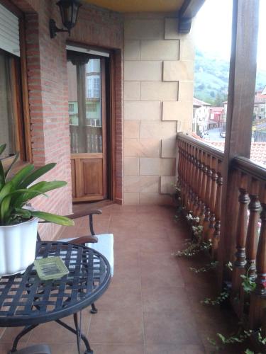 a porch with a bench and a table on a balcony at Posada Carpe Diem in Liérganes