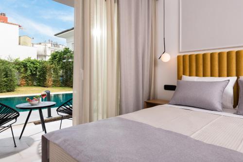 a bedroom with a bed and a balcony with a table at Alkyon Hotel in Limenas