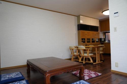 ein Wohnzimmer mit Tisch und Küche in der Unterkunft 吹屋庵 in Takayama