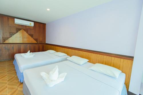 two white beds in a room with wood paneling at หาดตื้น คลื่นสวย รีสอร์ท - Hadtuen Kluensuay Resort in Chao Lao Beach
