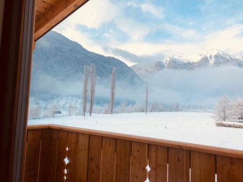 a view of a snowy mountain from a window at Fulun Mountain Lodge in Giustino