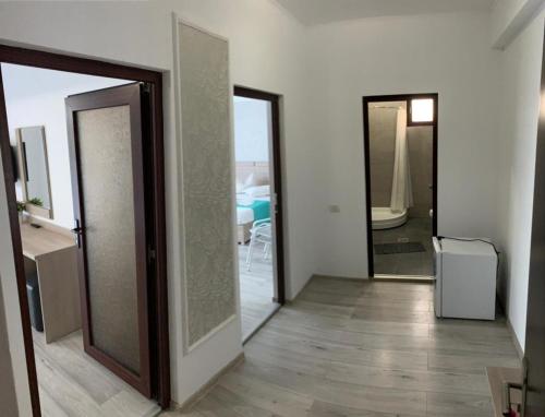 Ein Zimmer mit zwei Türen und ein Flur mit Holzboden in der Unterkunft Vila Elva in Eforie Sud