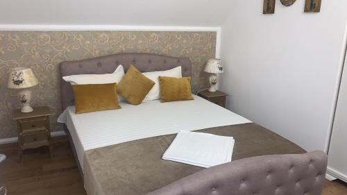 Una cama con almohadas amarillas y un sofá en una habitación en Casa Boem, en Mogoşoaia