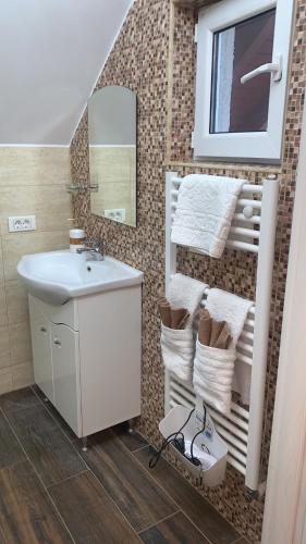 a bathroom with a sink and a mirror and towels at Casa Boem in Mogoşoaia