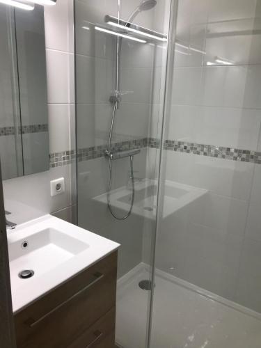 une salle de bain blanche avec une douche et un lavabo dans l'établissement Les terrasses de sylvabelle Apt 543, à La Croix-Valmer