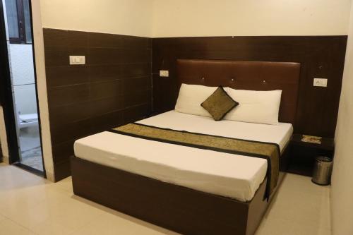 a bedroom with a large bed with white sheets and pillows at Hotel The Black Gold in Chandīgarh