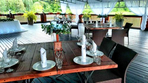 a wooden table on a deck with tables and chairs at Котедж-парк Славна in Okhtyrka