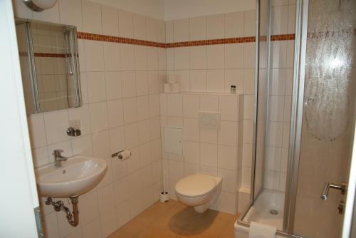 a bathroom with a toilet and a sink and a shower at Happy Go Lucky Hotel + Hostel in Berlin