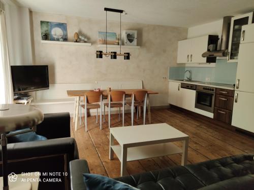 een keuken en een woonkamer met een tafel en stoelen bij Landhof Schober appartementen & kamers in Weissbriach