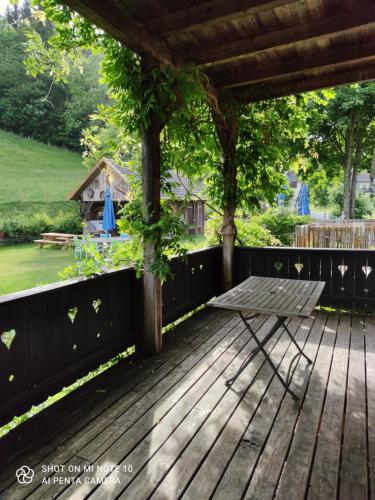 a wooden deck with a picnic table and a gazebo at Landhof Schober appartementen in Weissbriach