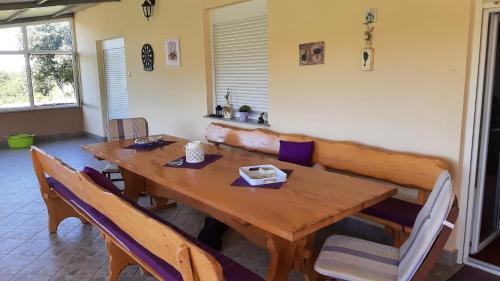 a wooden table and chairs in a room at Apartment Tina in Briševo