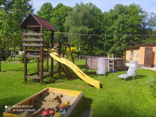 a playground with a slide and a swing set at Ubytování Pod statkem in Tichá