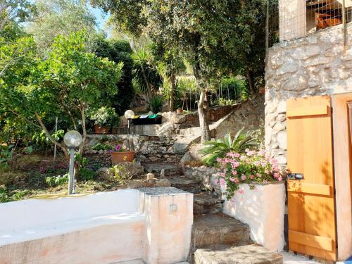 a garden with a stone wall and some flowers at Appartamento Vasiliki in Porto San Paolo