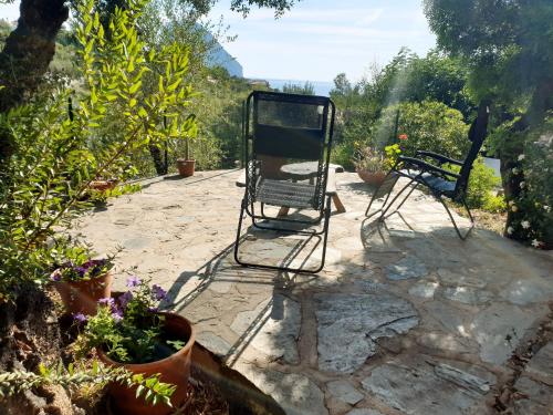 two chairs sitting on a patio with plants at Appartamento Vasiliki in Porto San Paolo