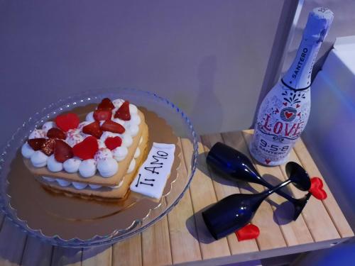 a cake on a table next to a bottle of wine at Suite Natura Bed&Beauty Spa in Taranto