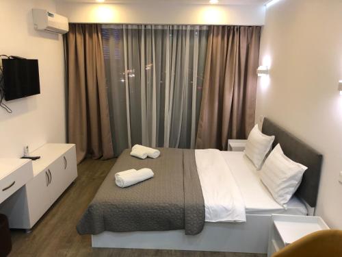 a bedroom with a bed with two towels on it at panorama beach tower in Batumi
