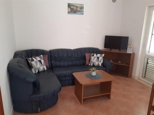 a living room with a blue couch and a table at Seven Seas Apartments in Mlini
