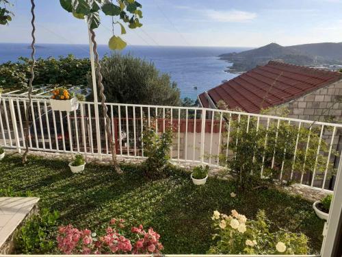 a white fence in a yard with a view of the ocean at Seven Seas Apartments in Mlini