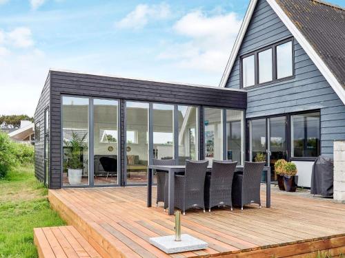 una casa con terrazza arredata con tavolo e sedie di 5 person holiday home in Fan a Fanø