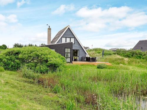 a house on a hill with a grass field at 5 person holiday home in Fan in Fanø