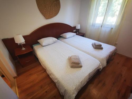 a bedroom with a bed with two towels on it at Airport Garden Apartments in Čilipi