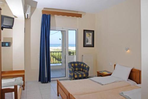 a hotel room with two beds and a window at Olympic Beach Hotel in Nei Poroi